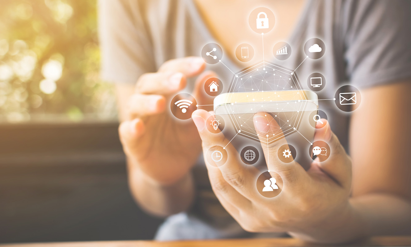 A person holding a cell phone with images of apps floating in a circle around it