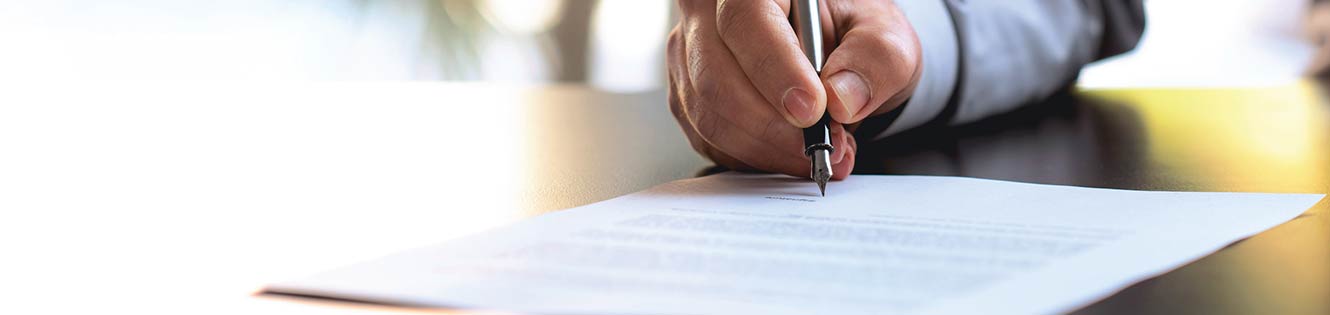 person with a pin in hand signing papers