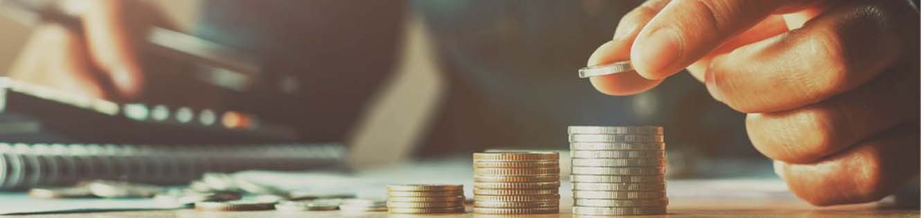 hand stacking coins on table