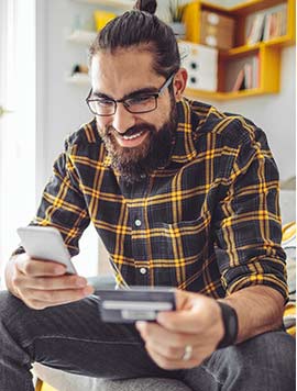 Man holding credit card and mobile phone.