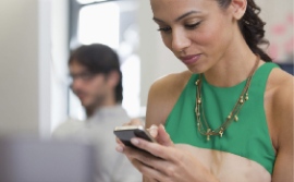 woman in a green outfit holding her cell phone