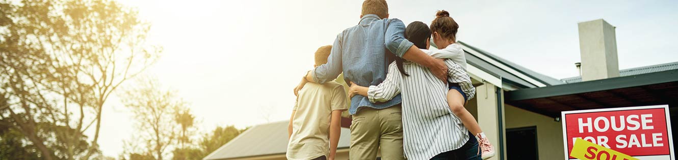 a family standing in front of their new house